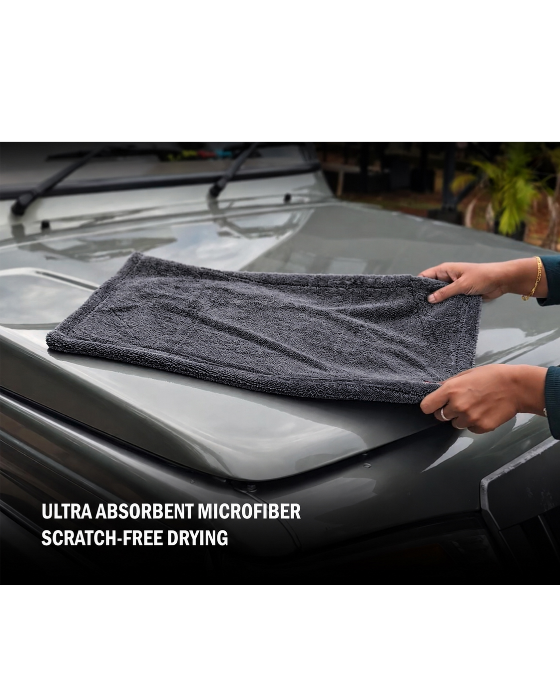 Microfiber car drying towel grey absorbing water on car hood